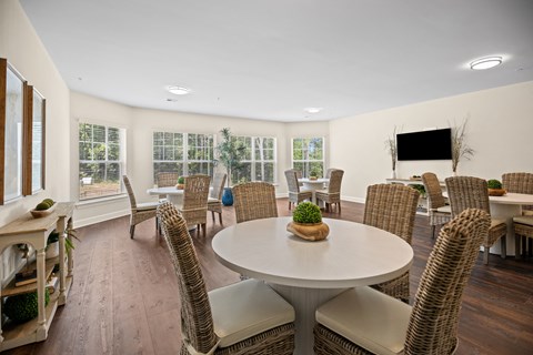 a living room with a table and chairs and a television