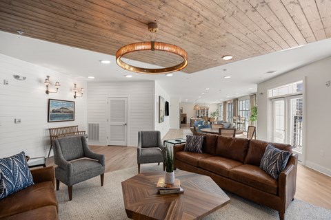 A living room with a brown leather couch and a wooden coffee table.