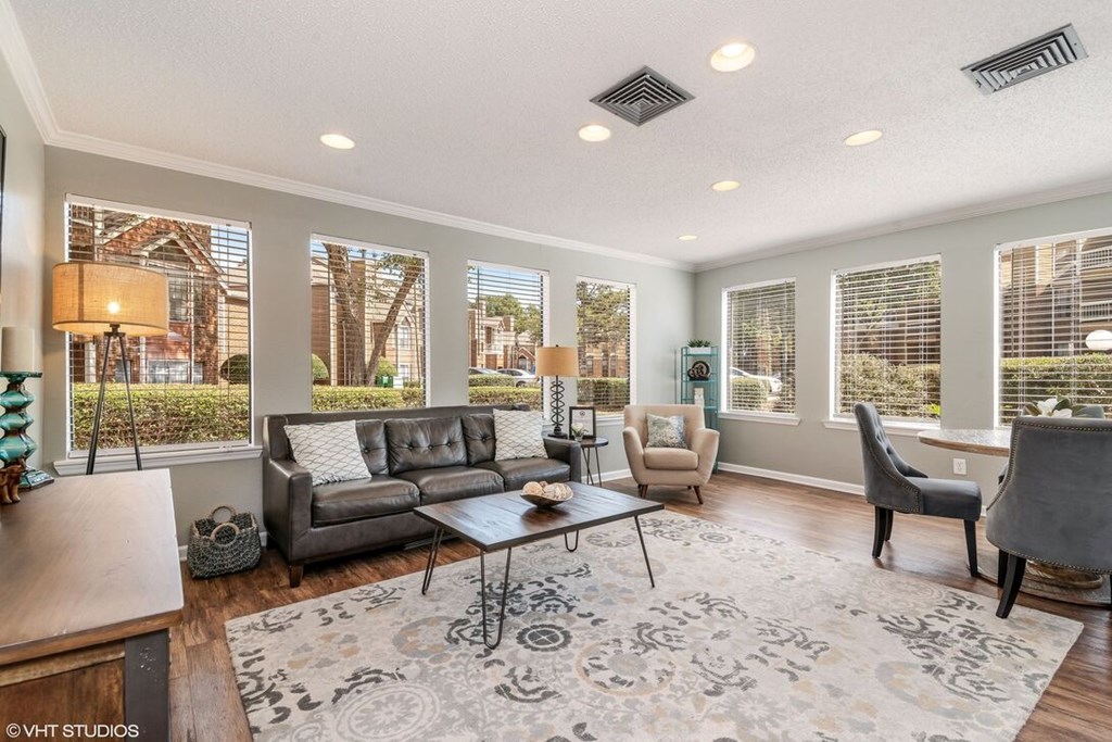 A well-lit living room with a grey sofa and a coffee table.