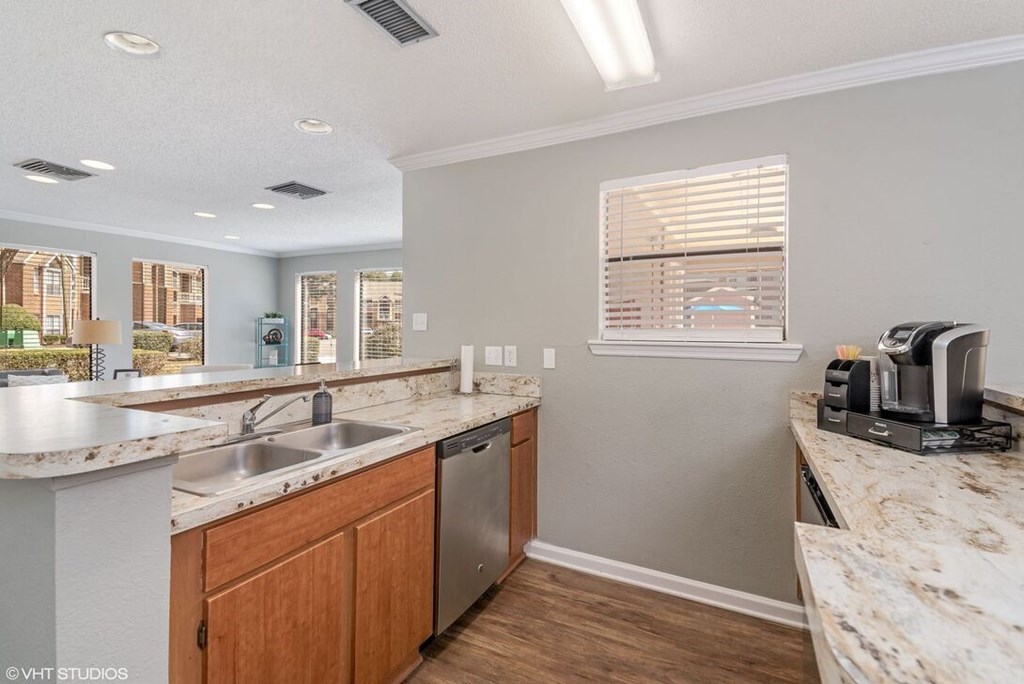 A kitchen with a marble countertop and wooden cabinets.
