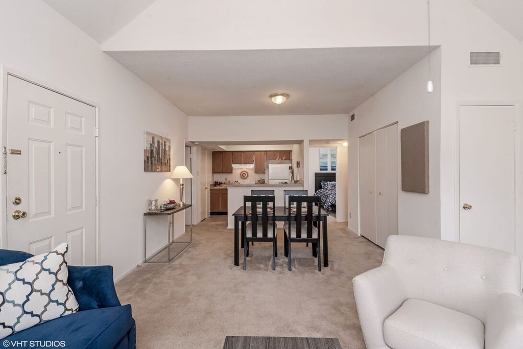 A living room with a blue couch and a white chair.