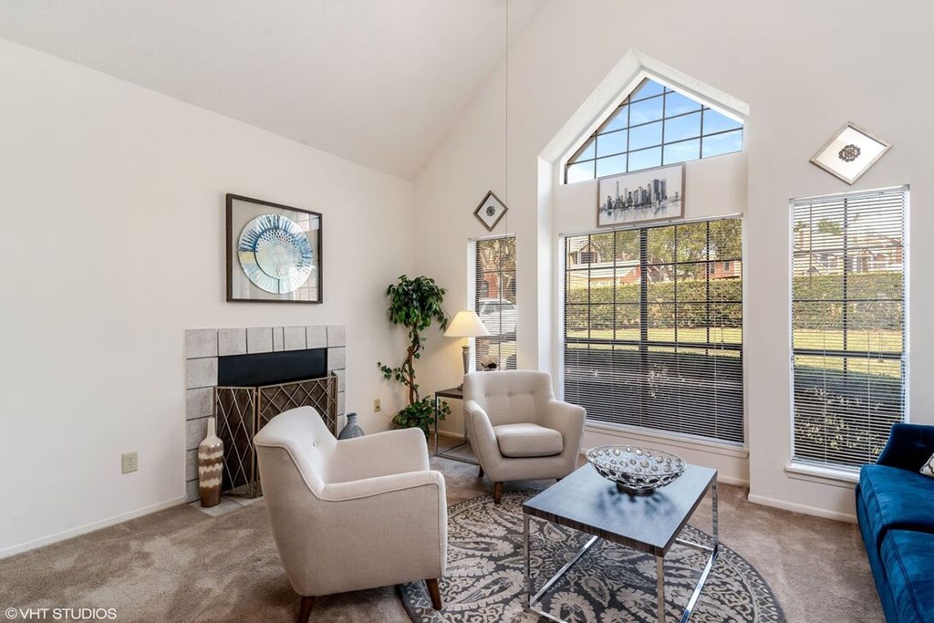 A living room with a fireplace, two chairs, and a coffee table.