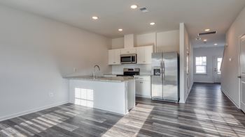 A modern kitchen with a refrigerator, microwave, and oven at The Mark Townhomes Apartments, Virginia, 22801
