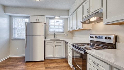 A kitchen with a stainless steel refrigerator and a white oven.