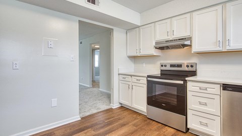 A kitchen with white cabinets and a stainless steel oven.