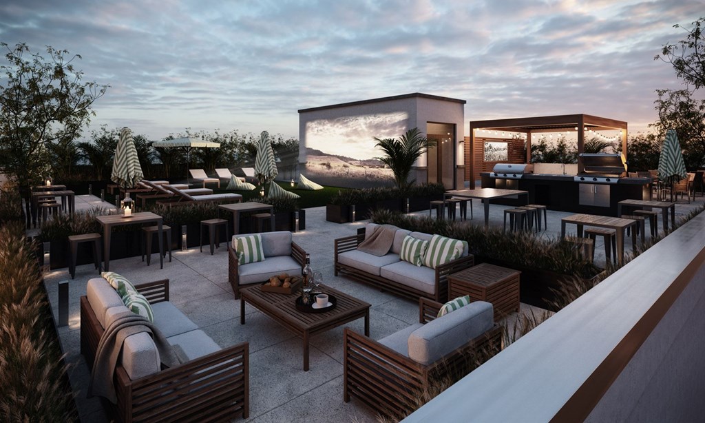 A modern outdoor seating area with a large screen and comfortable seating.at Aviator Lofts, Newport News, VA 23602