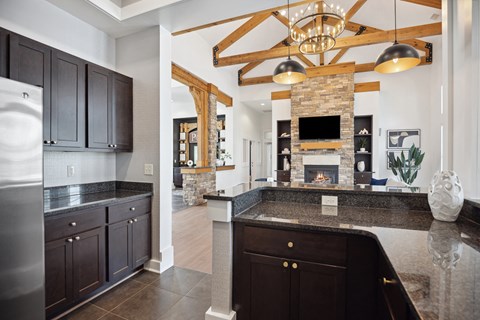 A modern kitchen with dark wood cabinets and a stone fireplace.