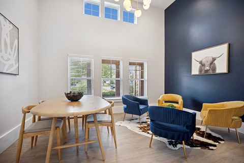 a dining room with a table and chairs and a bull painting on the wall