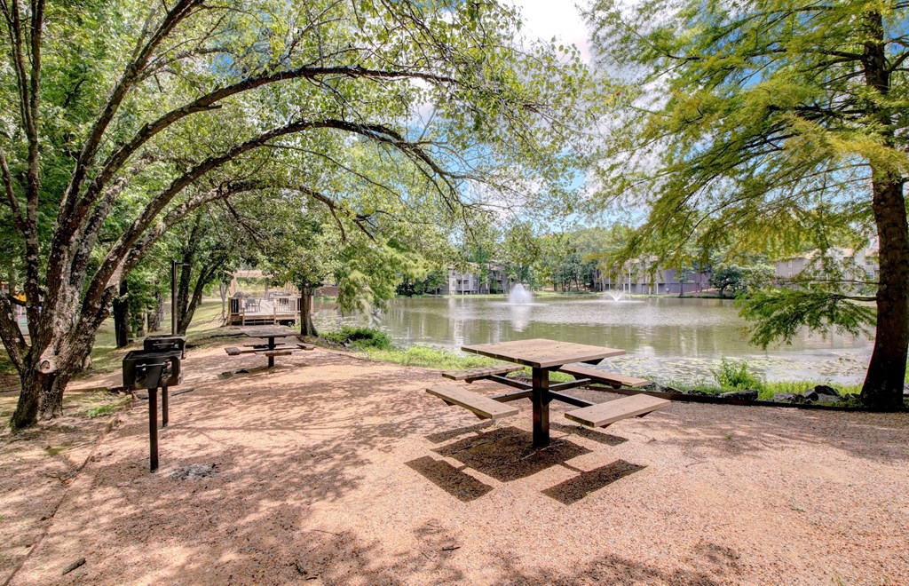 a picnic area with a picnic table next to a lake
