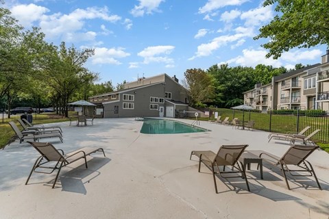 our apartments have a large pool and patio with chairs at Village 1373, Greensboro North Carolina