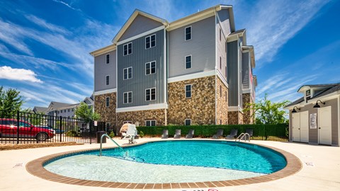 a swimming pool in front of an apartment building