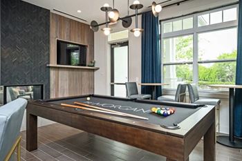 a games room with a pool table and a television