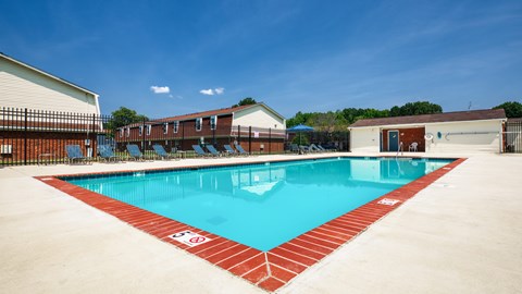 A large swimming pool with a red border and a white sign on the side.