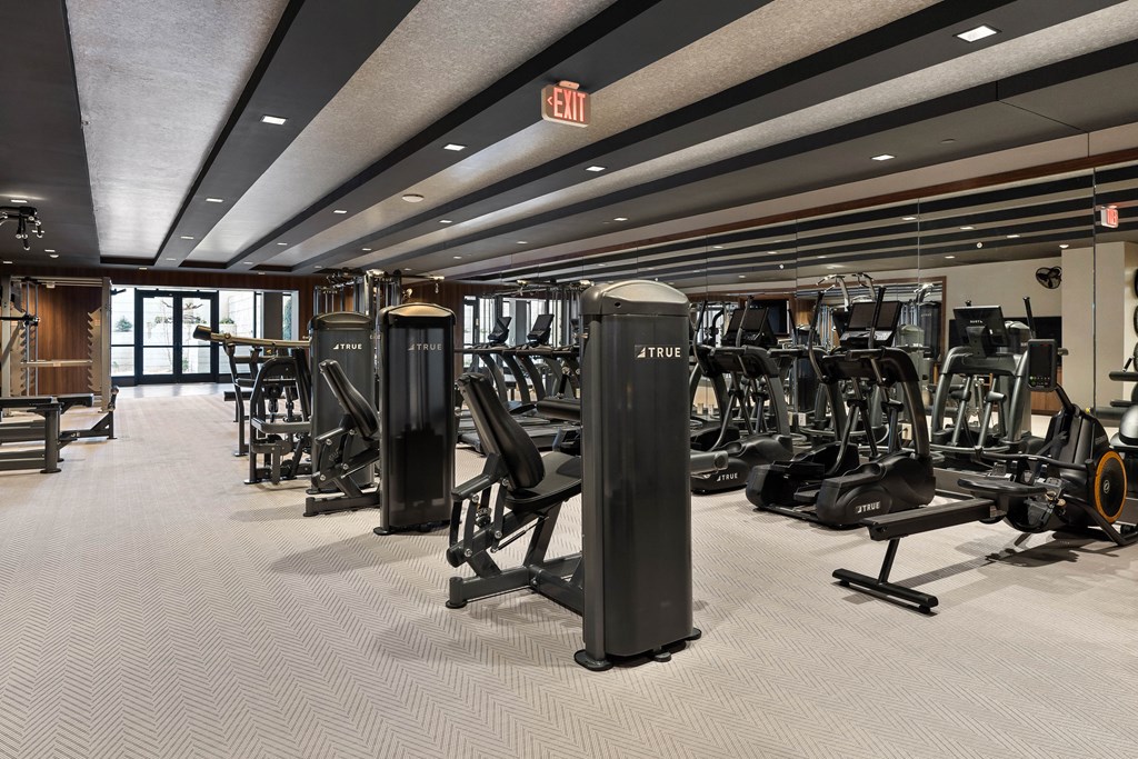 a gym with cardio machines and weights on the floor
