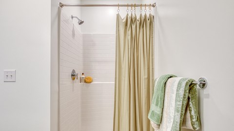 a bathroom with a shower curtain and towels in it at Allure at Edinburgh, Virginia, 23322