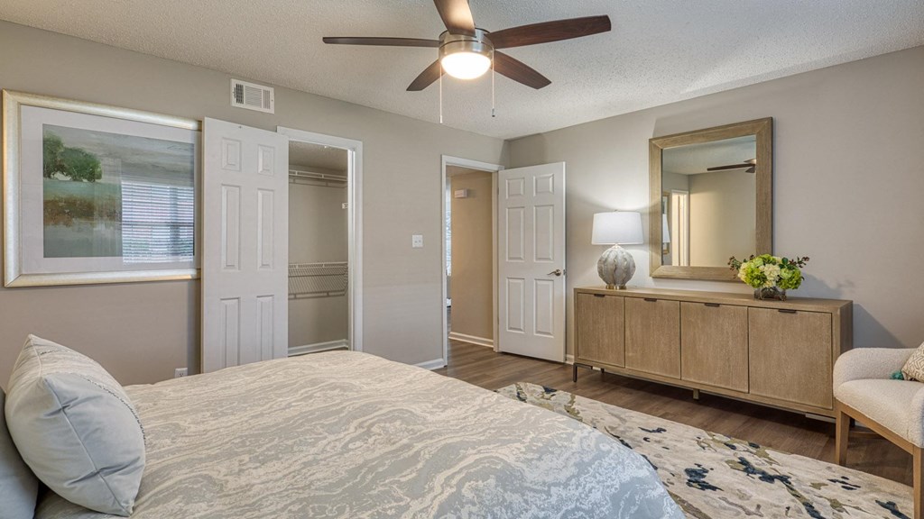 A bedroom with a bed, dresser, and mirror.