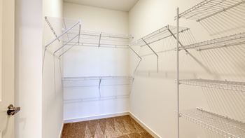 A walk in closet with shelves and a door at The Walker Virginia Center, Glen Allen, VA
