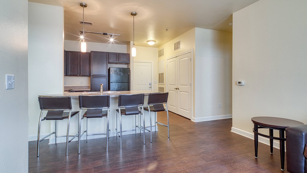 a living room with a kitchen bar and stools at Proximity at ODU, Virginia, 23508