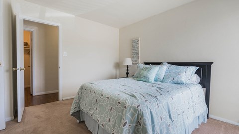 a bedroom with a bed and a door to a bathroom  at Bayville Apartments, Virginia, 23455