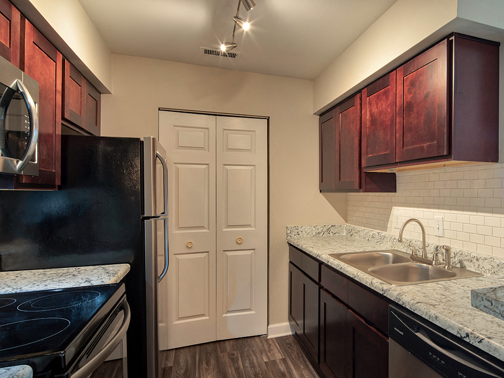 A kitchen with dark brown cabinets and a white door.