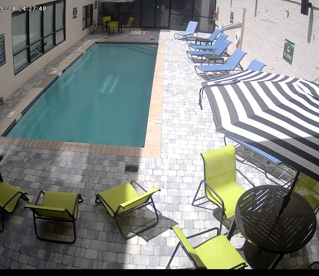 A pool surrounded by chairs and umbrellas.