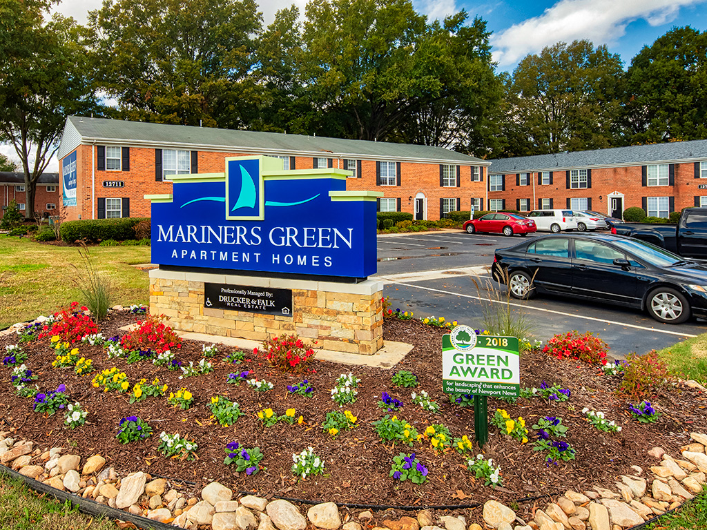 A sign for Mariners Green Apartment Homes sits in front of a building.