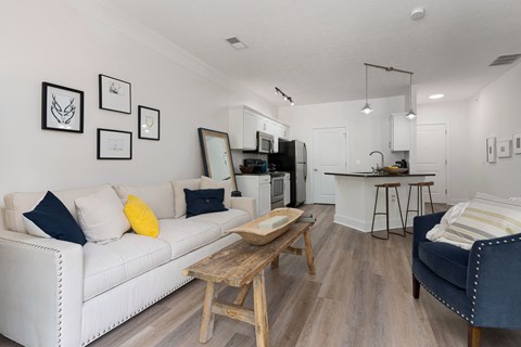 A living room with a white couch and a wooden coffee table.