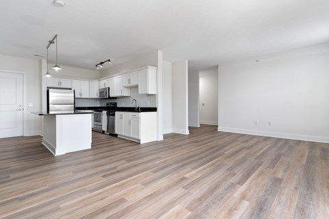 A kitchen with white cabinets and a wooden floor.