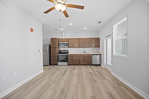 A kitchen with wooden cabinets and a ceiling fan.