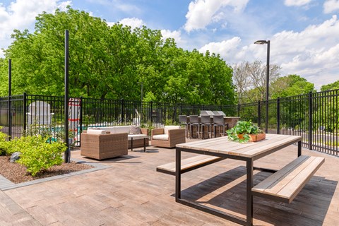 A wooden table and bench are set up on a patio.