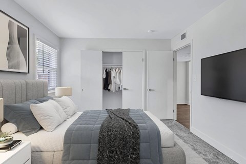 A modern bedroom with a large bed and a flat screen TV.