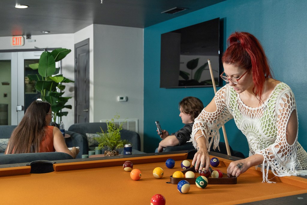 a woman playing a game of billiards on a pool table