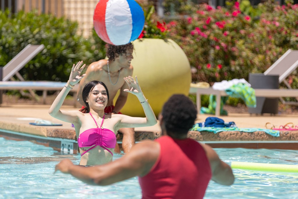 a group of people in a pool playing with a beach ball