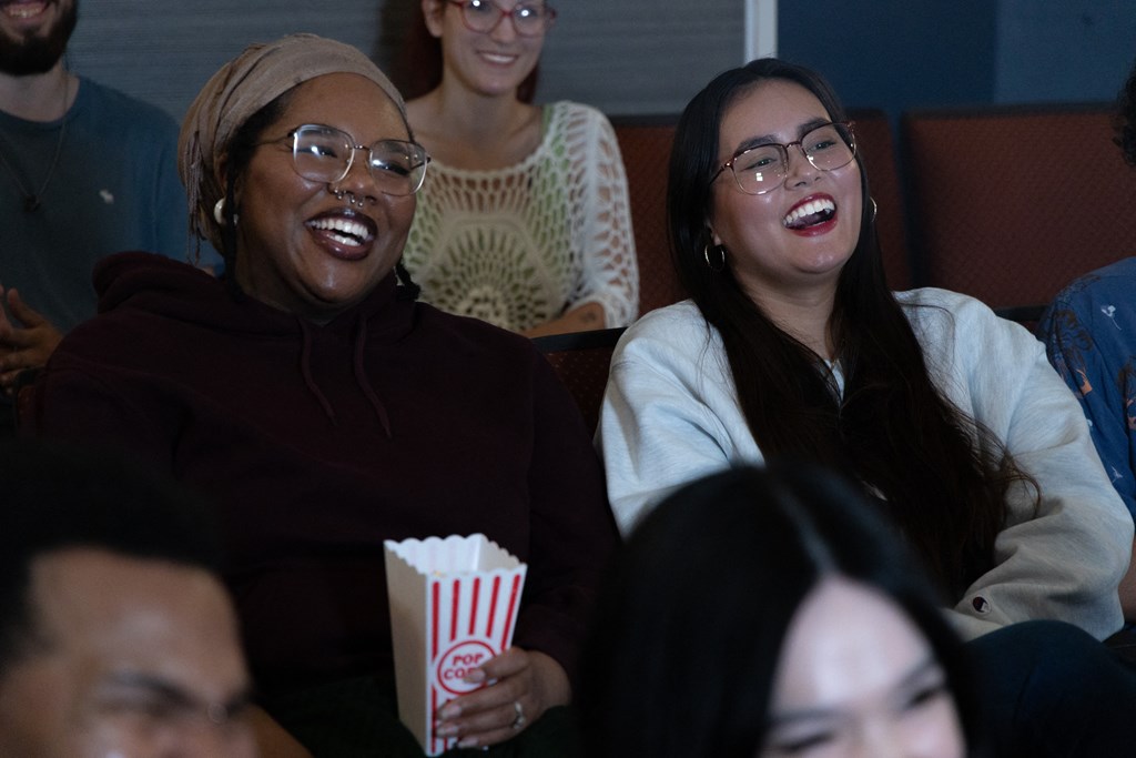 a group of people laughing in a movie theater