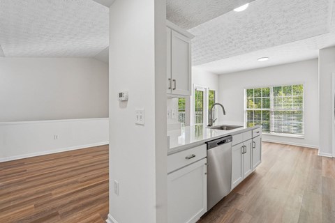 A kitchen with white cabinets and a stainless steel dishwasher.