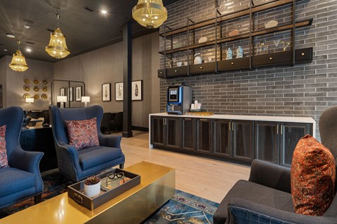 A living room with a blue chair and a black couch.
