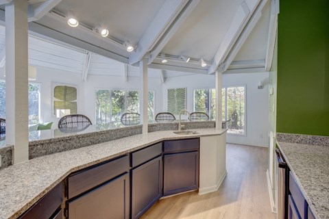 an open kitchen with granite counter tops and a large window