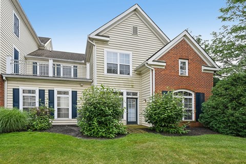 A house with a white and grey exterior and a red brick section.