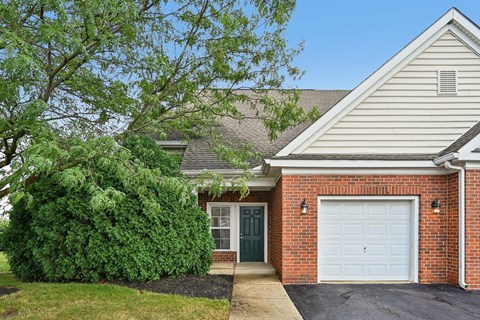 A house with a white garage door and a green door.