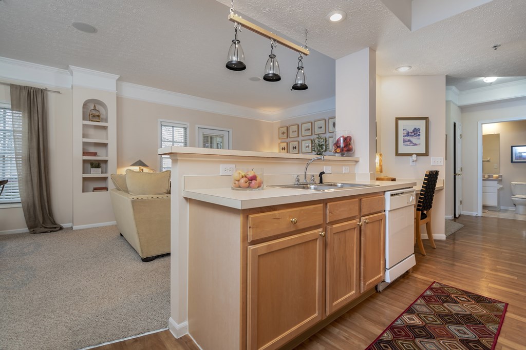 A kitchen with a white counter top and wooden cabinets. at The Orchard, Dublin, OH