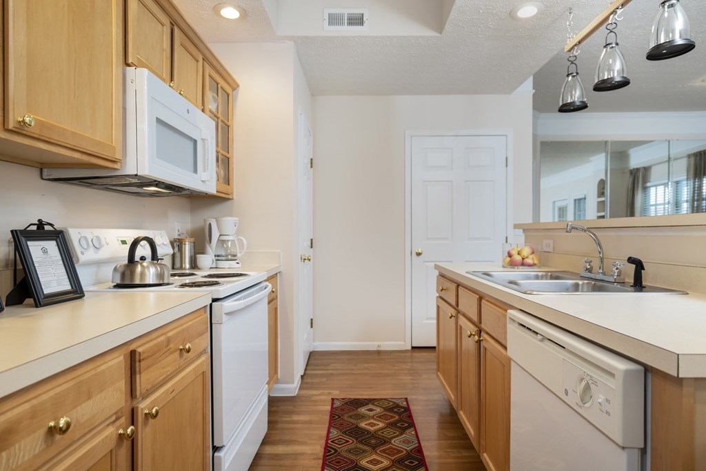 A kitchen with wooden cabinets and white appliances. at The Orchard, Ohio, 43016