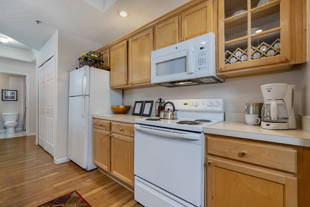 A kitchen with white appliances and wooden cabinets. at The Orchard, Dublin, OH