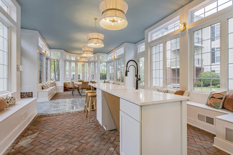 A kitchen with a white counter and wooden chairs.