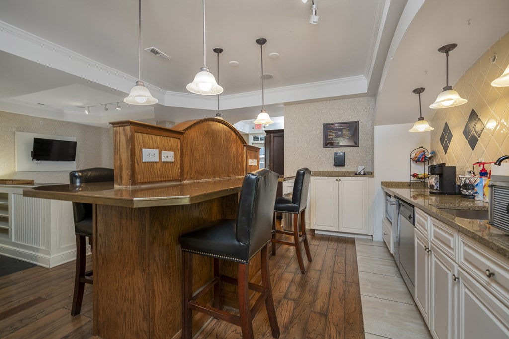 A kitchen with a bar area and a black chair. at Times Square, Dublin, Ohio