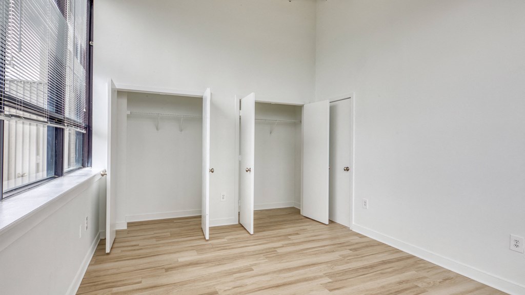 a bedroom with hardwood floors and white walls  at The Hudson, Virginia