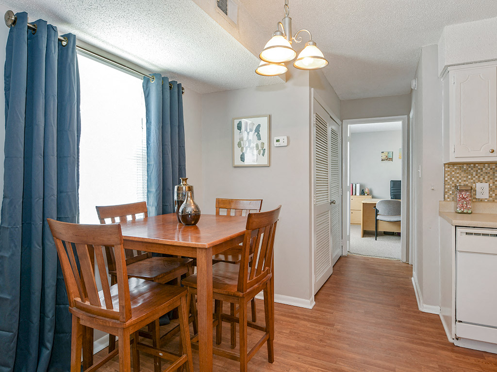 A dining room with a table and chairs.
