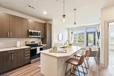 A modern kitchen with wooden cabinets and a white island.