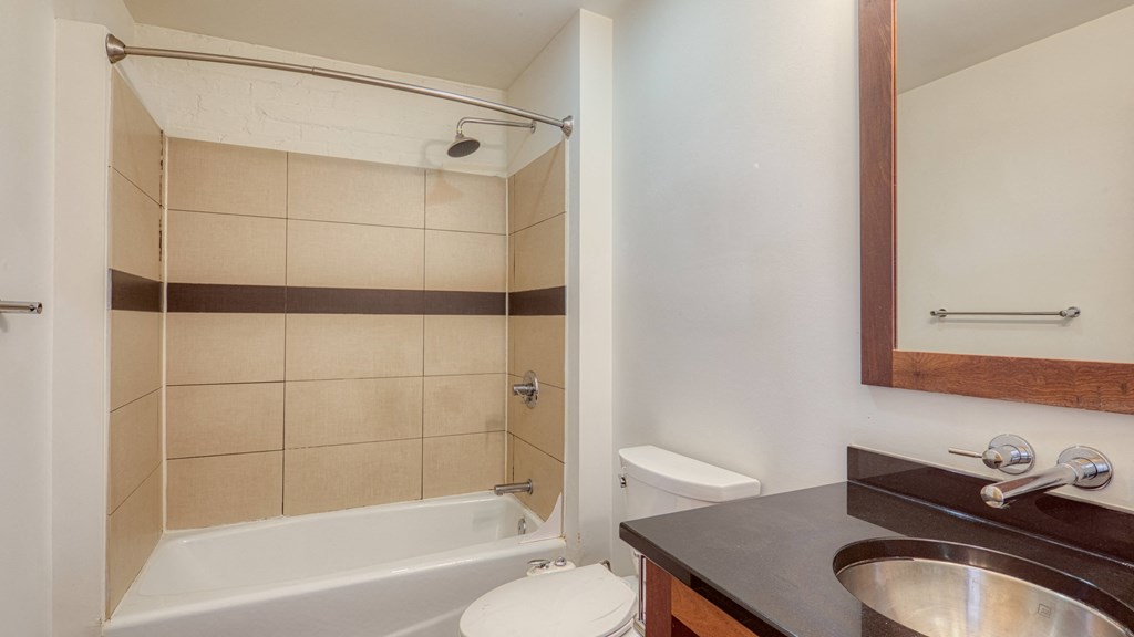 a bathroom with a shower toilet and sink and a mirror