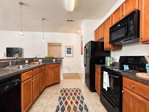 a kitchen with black appliances and wooden cabinets