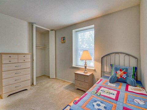 a bedroom with a bed and a dresser and a window